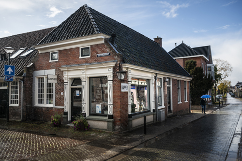 Winkelstraat met een pand waar een kapsalon in is gevestigd.