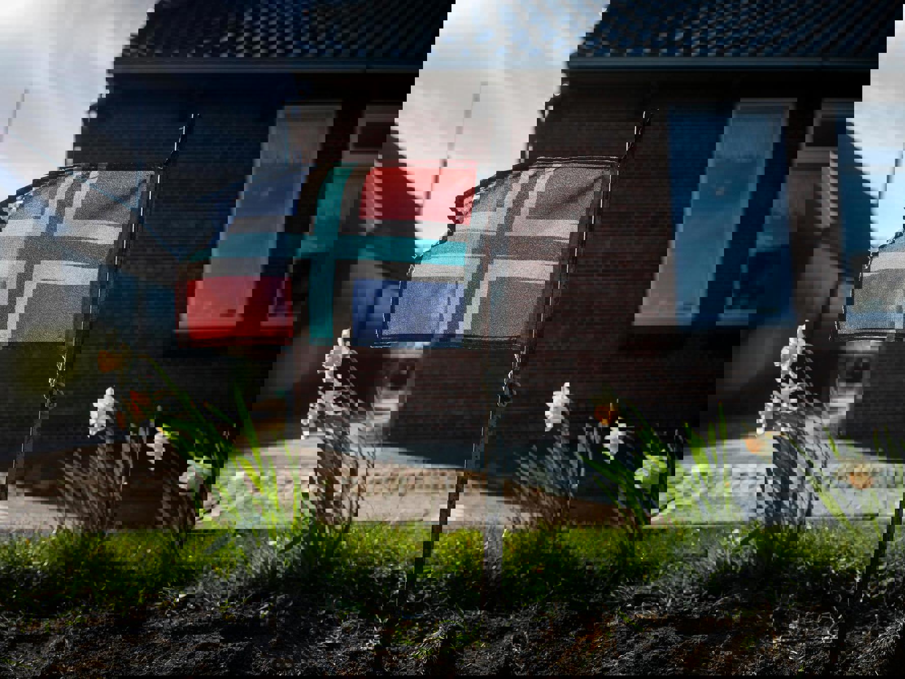 In een tuintje in Holwierde wappert een Gronings vlaggetje tussen de bloemen