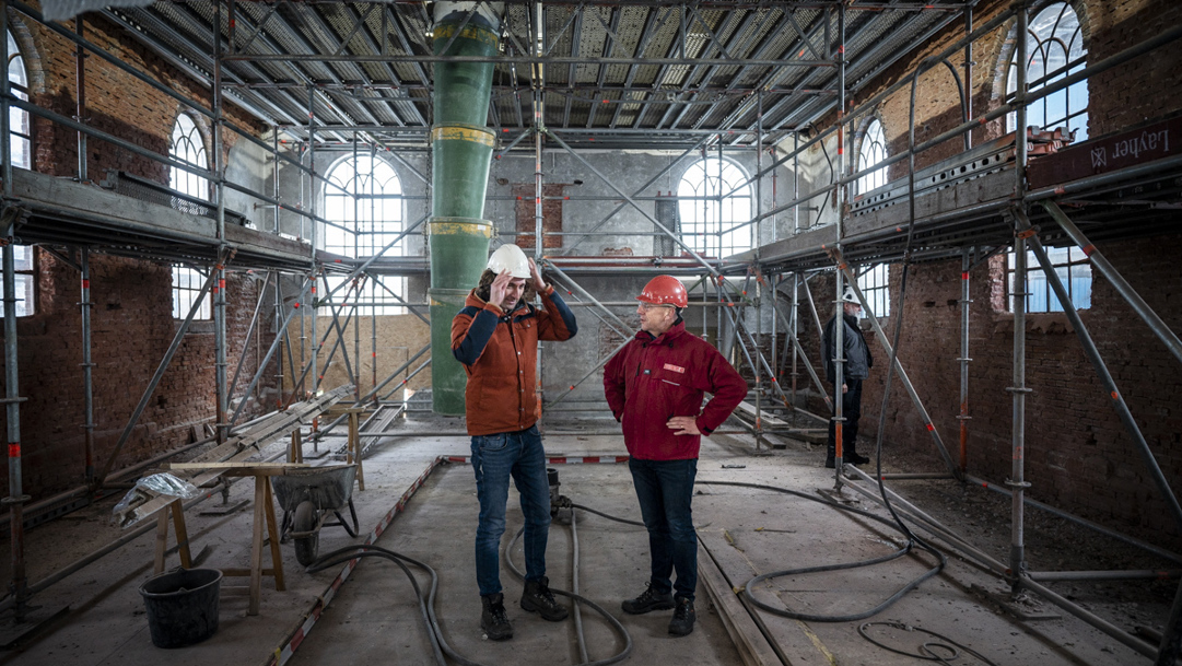 Restauratie-architect Daniël van Huizen en bouwkundige Jur Bekooy. in de kerk van Overschild.