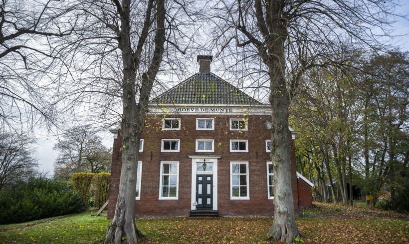150-jaar oude boerderij in Tussenklappen met twee bomn ervoor.