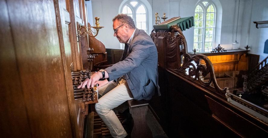 Bert Smit, van de Stichting Beheer Kerkelijk Erfgoed Oostwold, bespeelt het orgel van de kerk