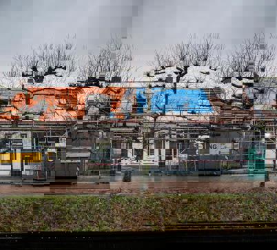 Het vooraanzicht van twee historische panden die in de steigers staan in het centrum van Loppersum.
