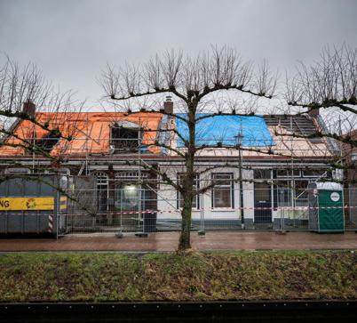 Het vooraanzicht van twee historische panden die in de steigers staan in het centrum van Loppersum.