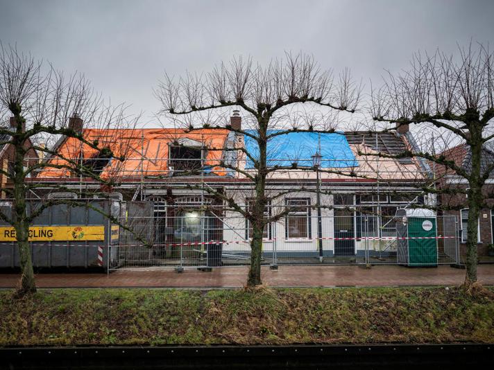 Het vooraanzicht van twee historische panden die in de steigers staan in het centrum van Loppersum.