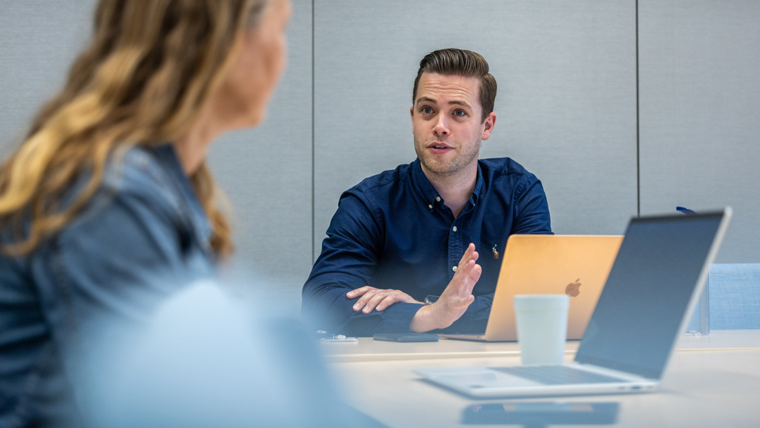 Frank werkt met een collega op kantoor.