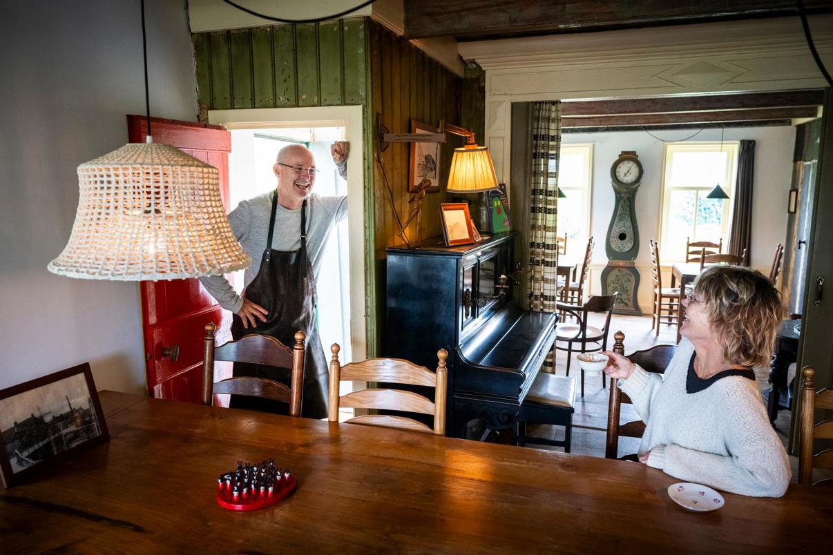 Mirjam aan de tafel in het huiskamercafé en Peter in de deuropening.