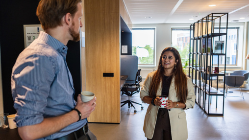 Fena drinkt koffie met een collega.