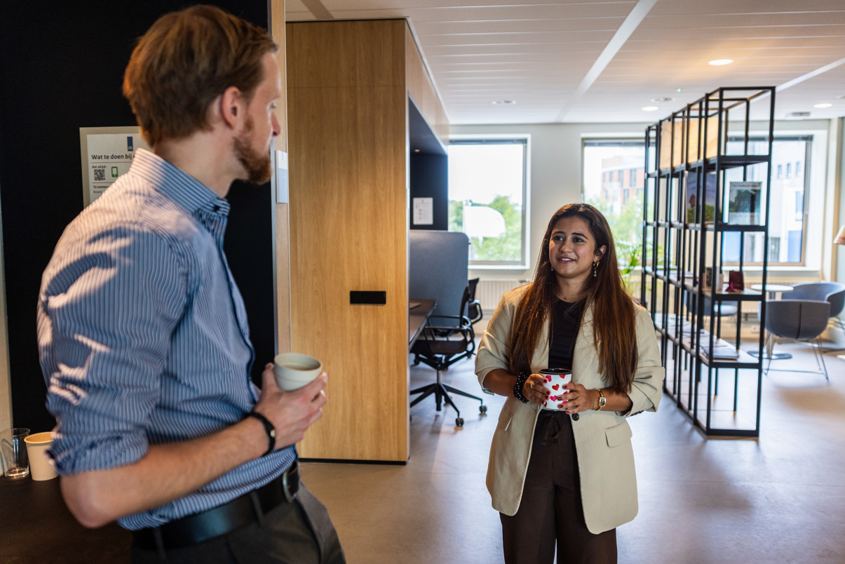 Fena drinkt koffie met een collega.