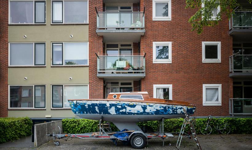 Een bootje staat op een aanhanger voor een appartementencomplex in Sappemeer.