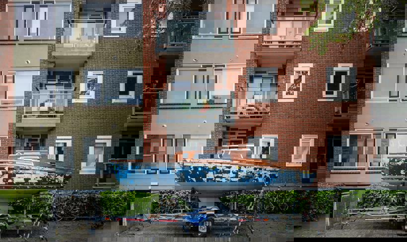 Een bootje staat op een aanhanger voor een appartementencomplex in Sappemeer.