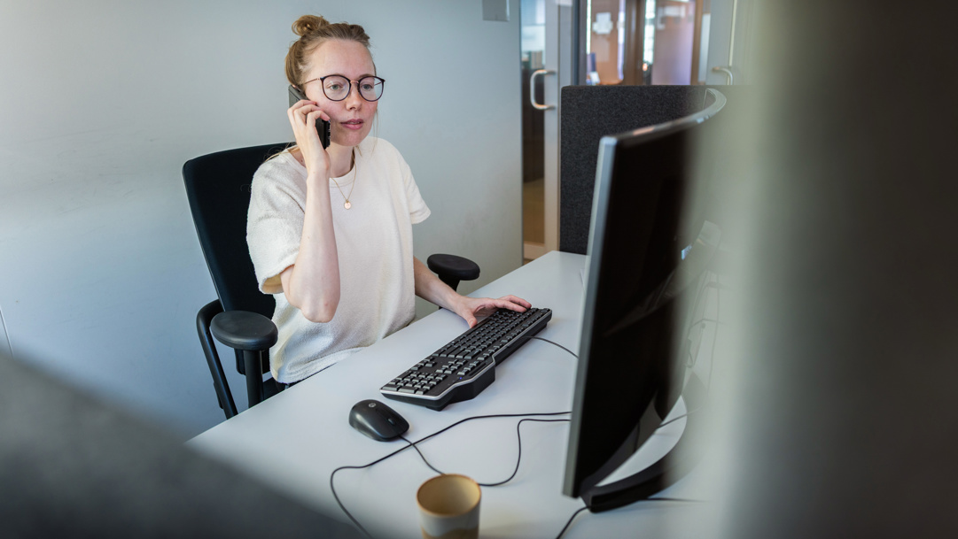 Dieuwke is aan het werk achter haar bureau en zit te telefoneren.