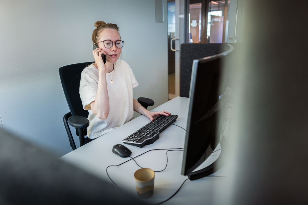 Dieuwke is aan het werk achter haar bureau en zit te telefoneren.