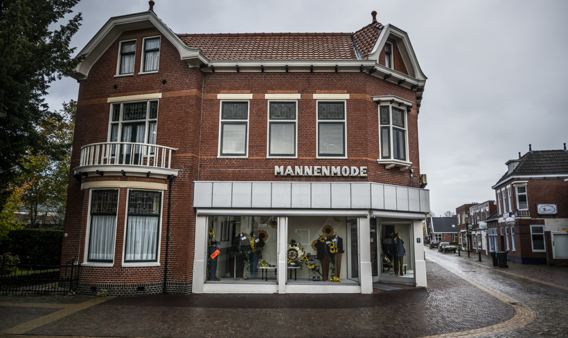 Pand waar wonen en werken wordt gecombineerd. Met onderin een winkel voor mannenmode en bovenin een woning.