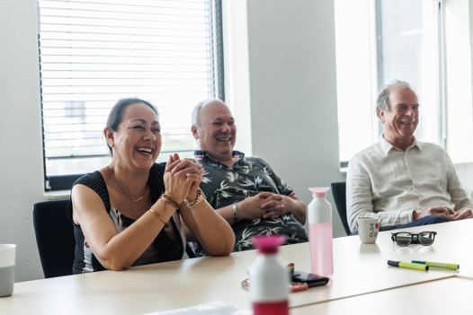 Collega's lachen met elkaar tijdens een vergadering. 