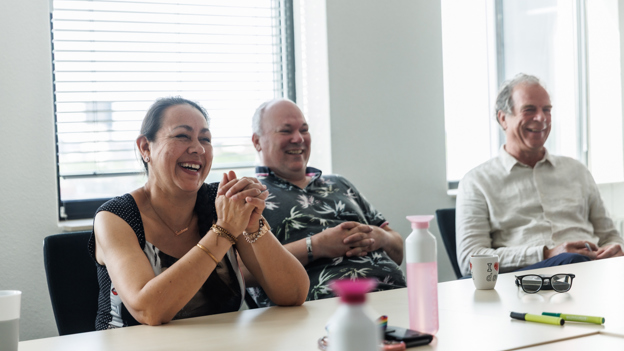Collega's lachen met elkaar tijdens een vergadering. 