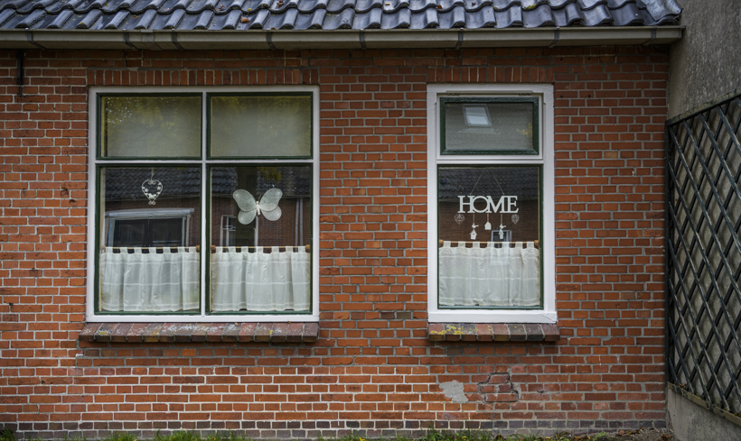 Buitenkant van een woning met woondecoraties in de vensterbank. 