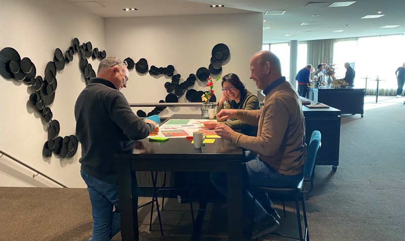 Drie medewerkers van het ICT zitten aan een tafel.