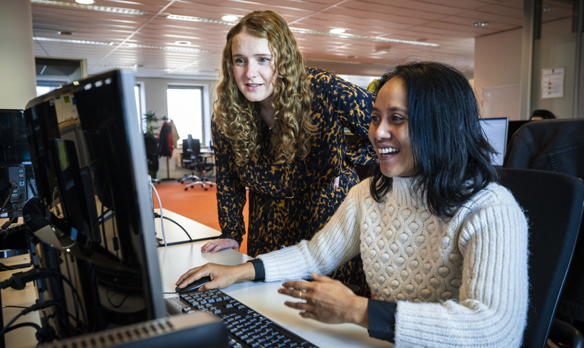 Ayla kijkt samen met een collega naar een beeldscherm