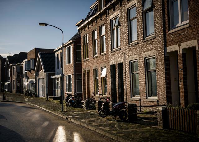 Een rij woningen in de zon met een blauwe lucht op de achtergrond.