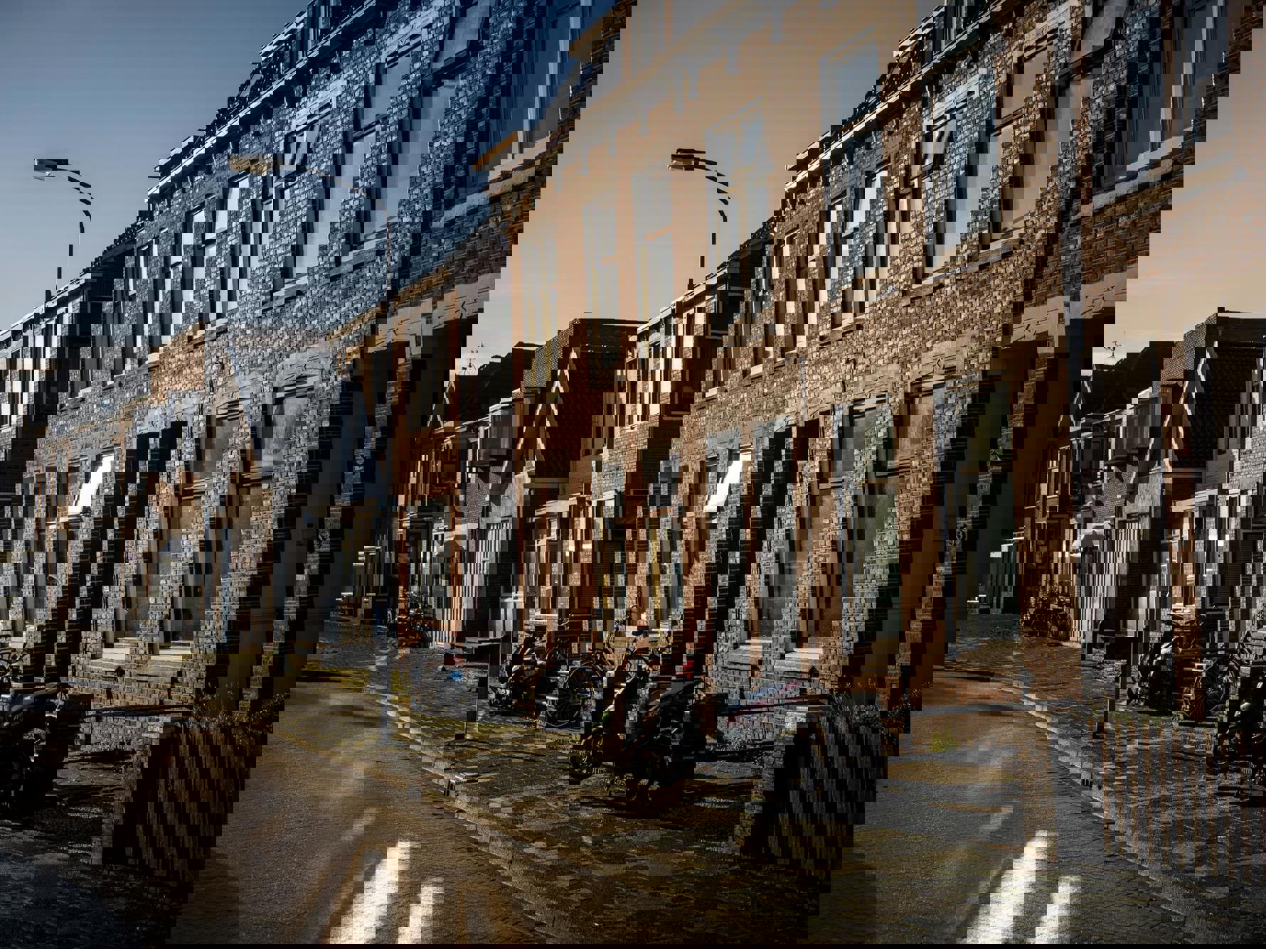 Een rij woningen in de zon met een blauwe lucht op de achtergrond.