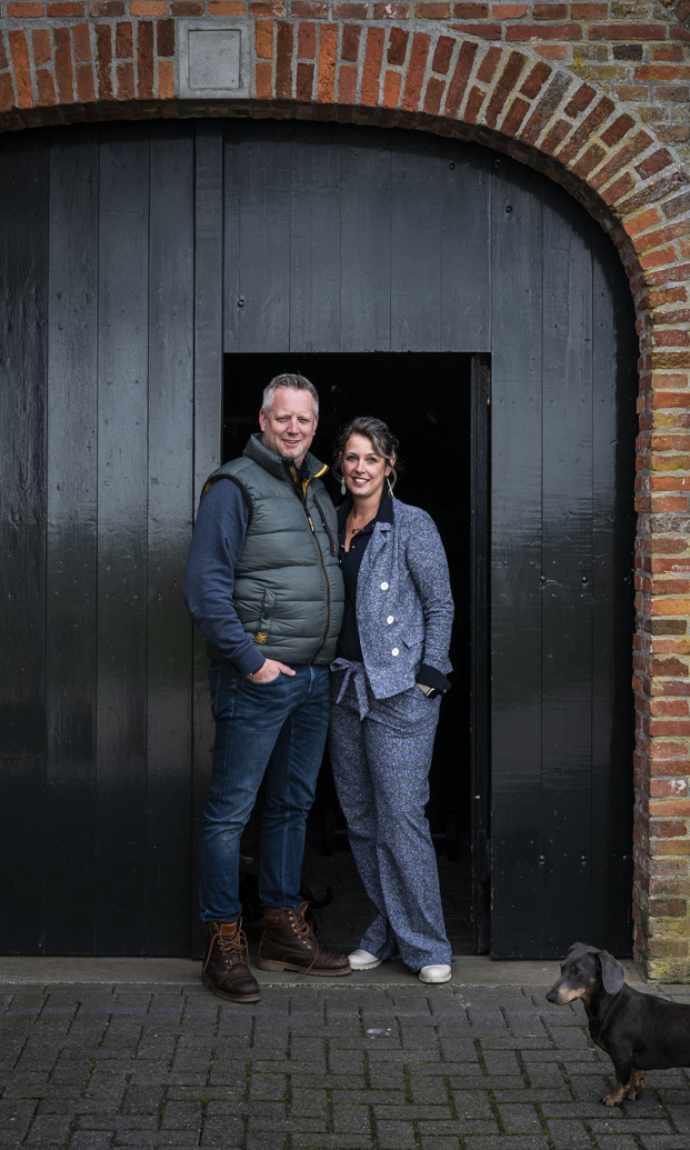 Linda Heuker en haar vriend voor de oude staldeur van hun huis.