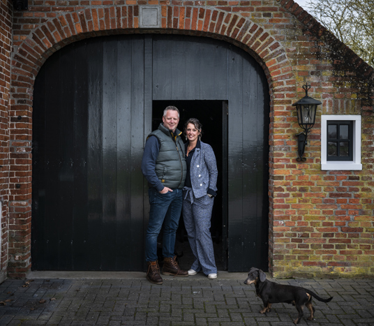 Linda Heuker en haar vriend voor de groene staldeur van hun rentenierswoning in 't Zandt