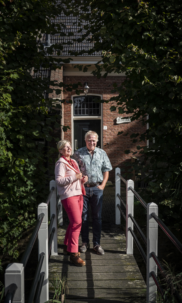Ineke en Wim van Zanten staan op het bruggetje naar hun boerderij.