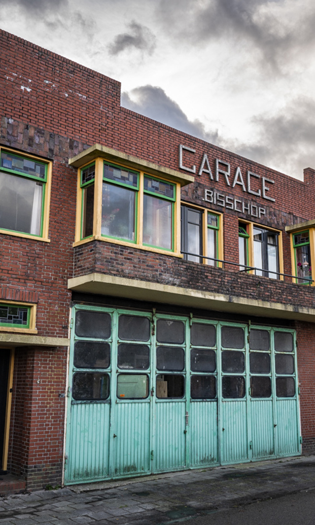 Gevel met blauw geverfde deuren van de voormalige busremise in Kantens. 