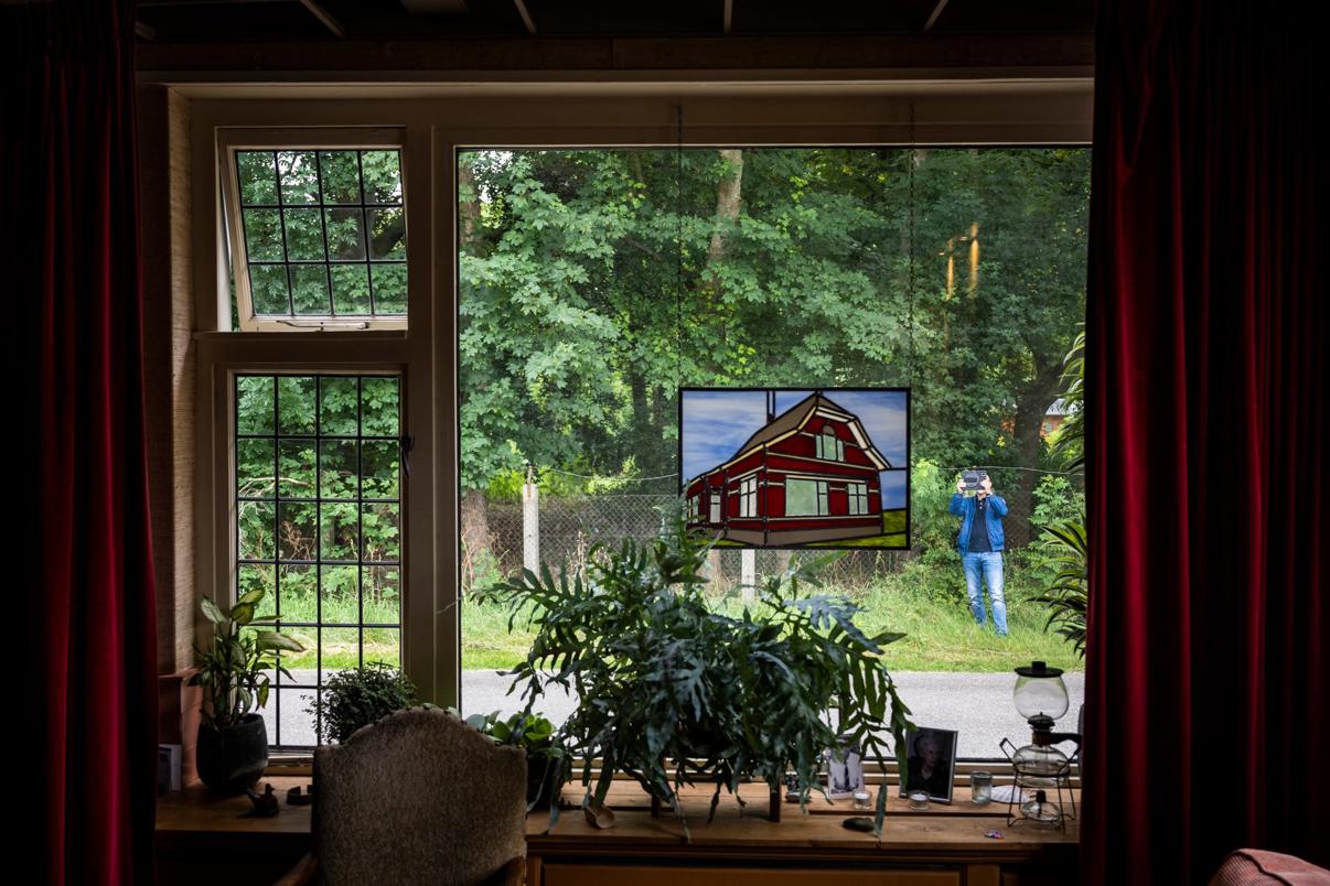 Een onafhankelijk expert fotografeert de buitenkant van een woning ter inventarisatie van eventuele aardbevingsschade.