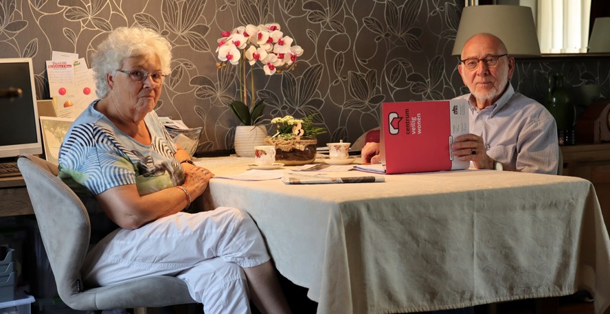 Sjouk en Jan Dijkhuizen zitten aan tafel met kopjes koffie en een map van Centrum Veilig Wonen in de hand