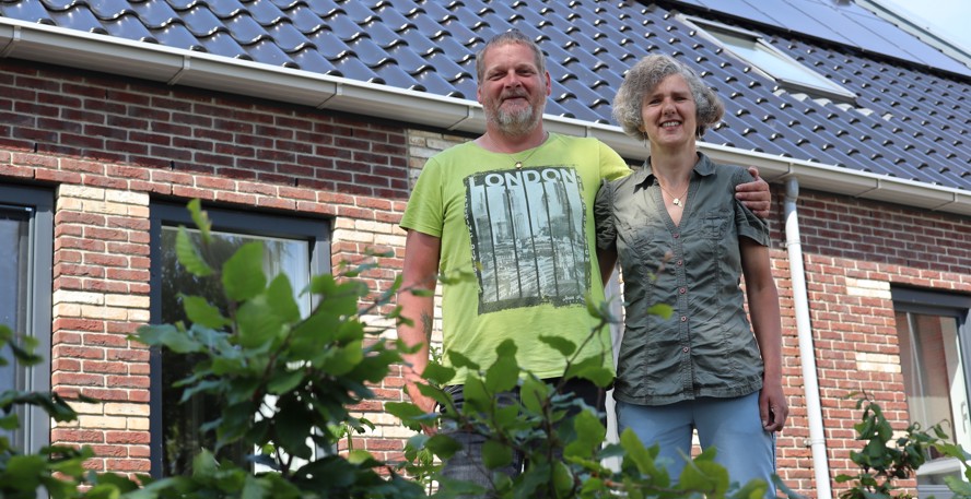 Gezina en Kenny Buitendam in de tuin bij hun huis, op het dak liggen zonnepanelen