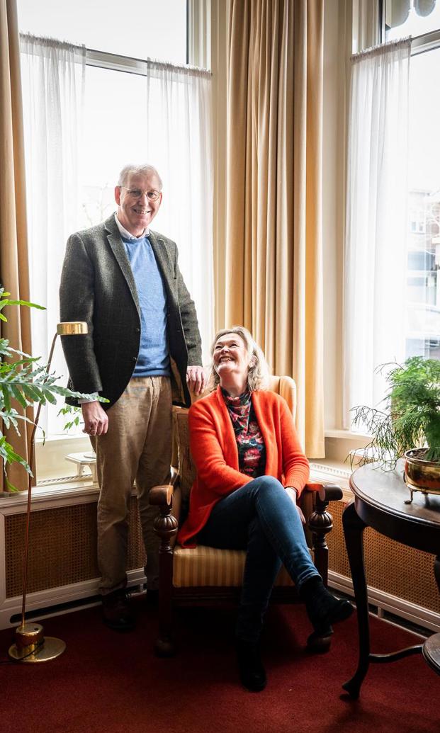 Joop en Erna Leffers zitten op een stoel in de woonkamer van hun huis.