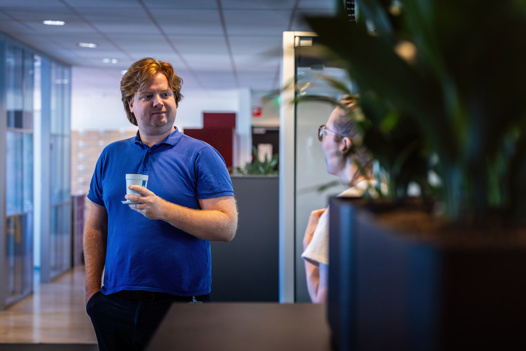 Niels houdt een kop koffie vast op zijn afdeling.