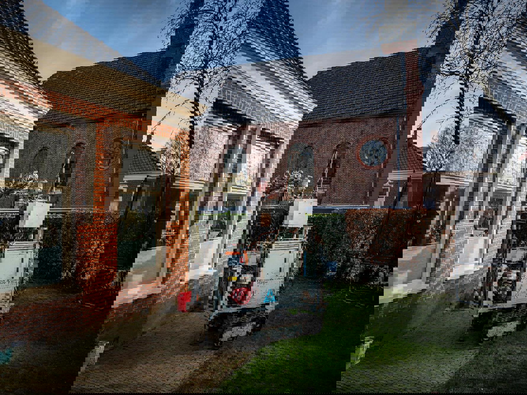 In de tuin van een woning wordt constructief onderzoek uitgevoerd.