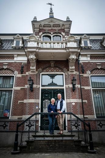 Huisarts-in-ruste Joost Boskamp en zijn vrouw voor hun huis in Bedum.
