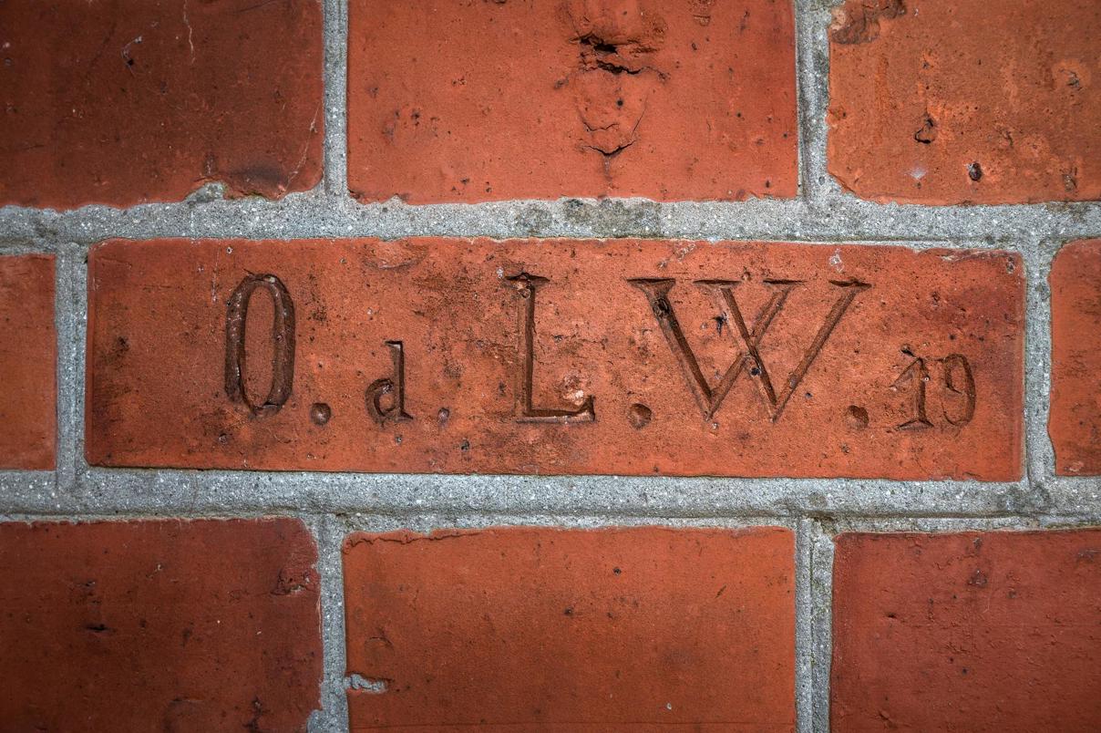 De initialen van architect Oeds in een baksteen van zijn huis.